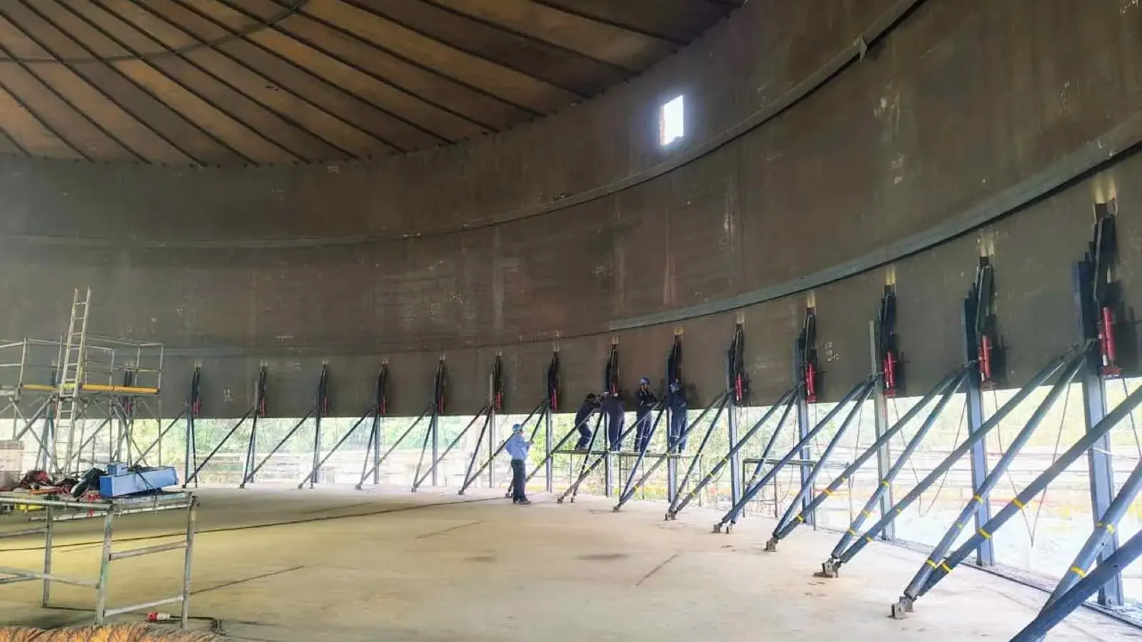Hydraulic jacks set around the inside of an ammonia tank shell during reverse-jacking dismantling at Birla Copper, Dahej